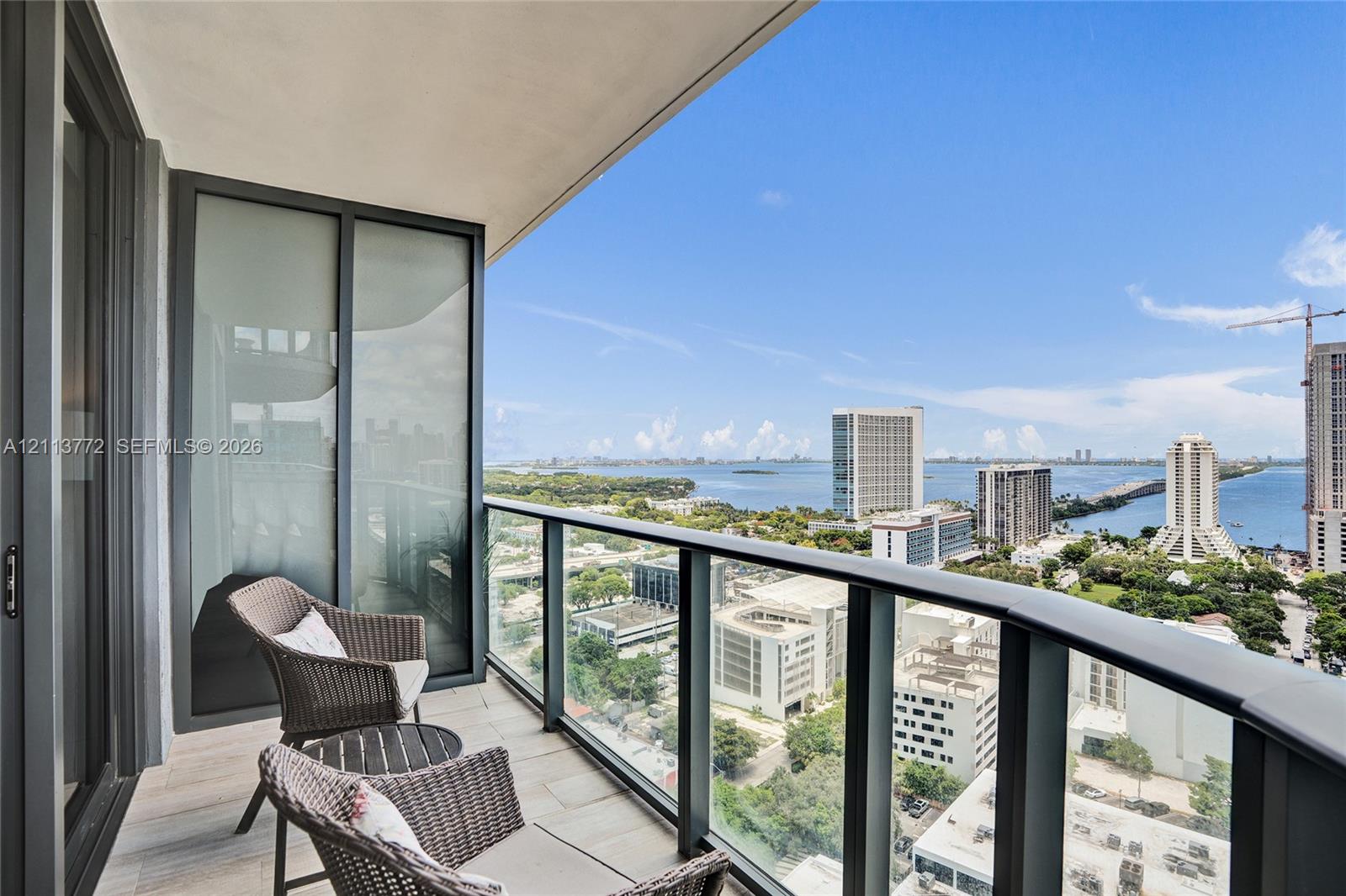 Private balcony featuring tile flooring and a glass-paneled railing