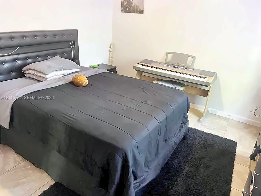 Room featuring neutral wall finishes and large-format tile flooring
