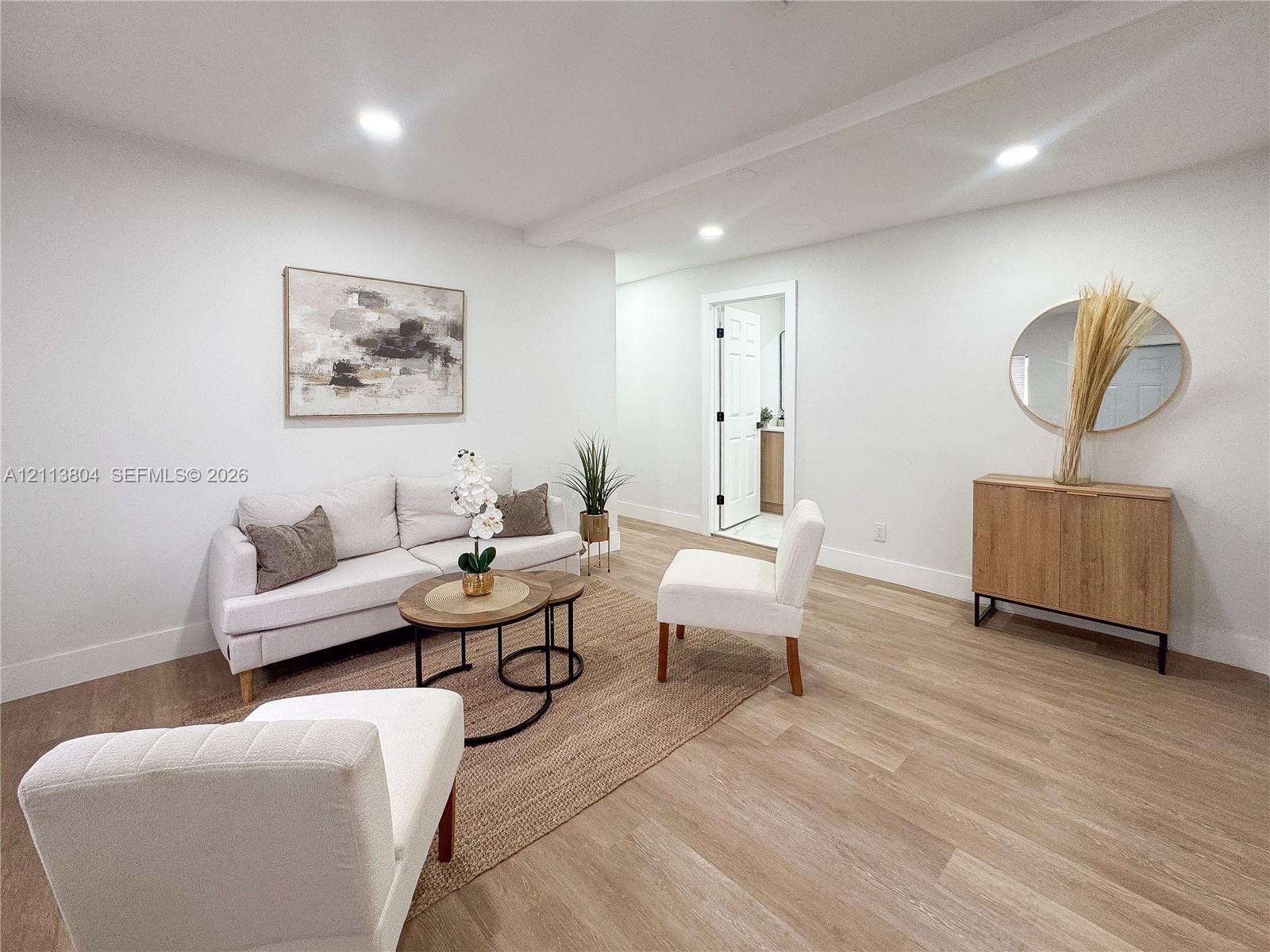 Open-concept space featuring recessed ceiling lighting, neutral walls, and wood-finish flooring Open-concept space featuring recessed ceiling lighting, neutral walls, and wood-finish flooring