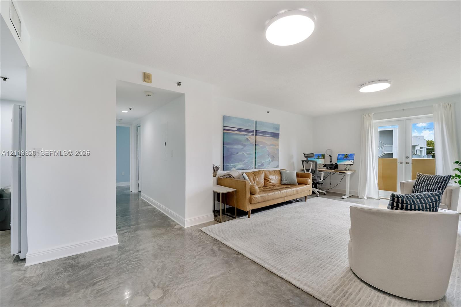 Polished concrete flooring, recessed lighting, and double glass-paned doors providing exterior access Polished concrete flooring, recessed lighting, and double glass-paned doors providing exterior access