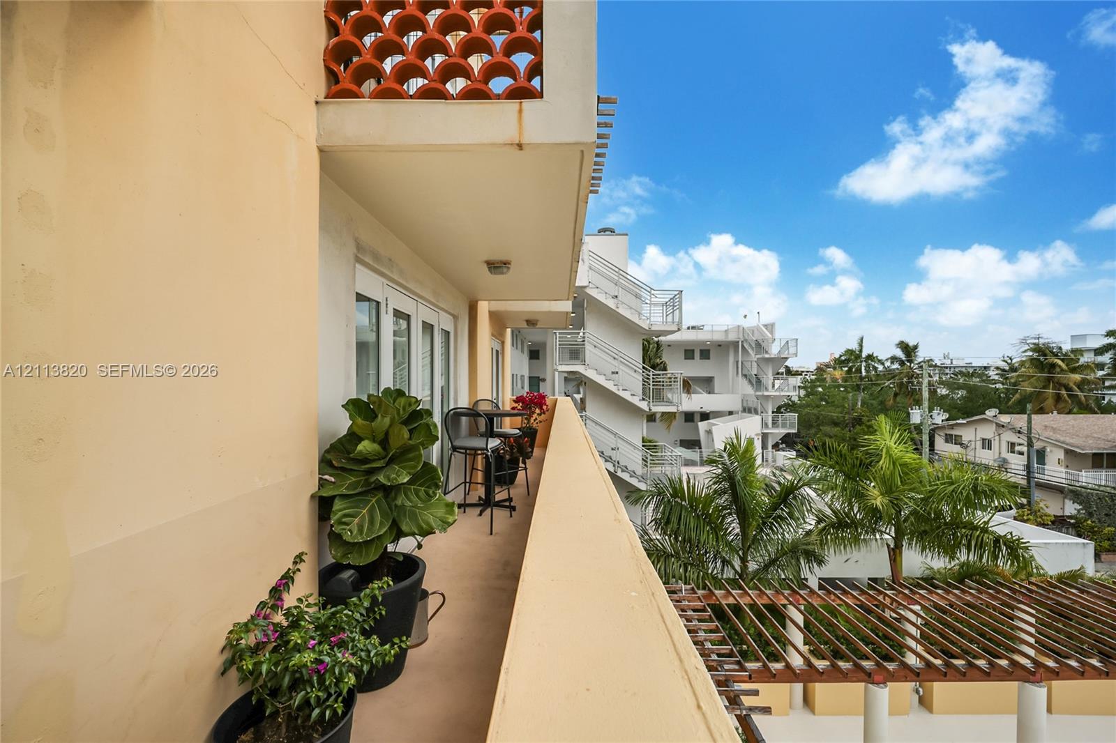 Private balcony featuring terracotta breeze block accents and a slatted timber pergola covering the area below Private balcony featuring terracotta breeze block accents and a slatted timber pergola covering the area below