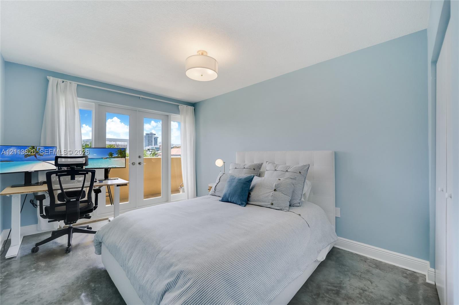 Polished concrete flooring, dual-pane French doors with exterior access, drum-style ceiling light fixture, and white double-door closet cabinetry Polished concrete flooring, dual-pane French doors with exterior access, drum-style ceiling light fixture, and white double-door closet cabinetry