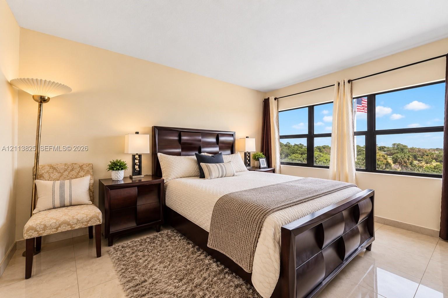 Bedroom featuring tile flooring, neutral wall tones, and large horizontal windows with exterior landscape exposure