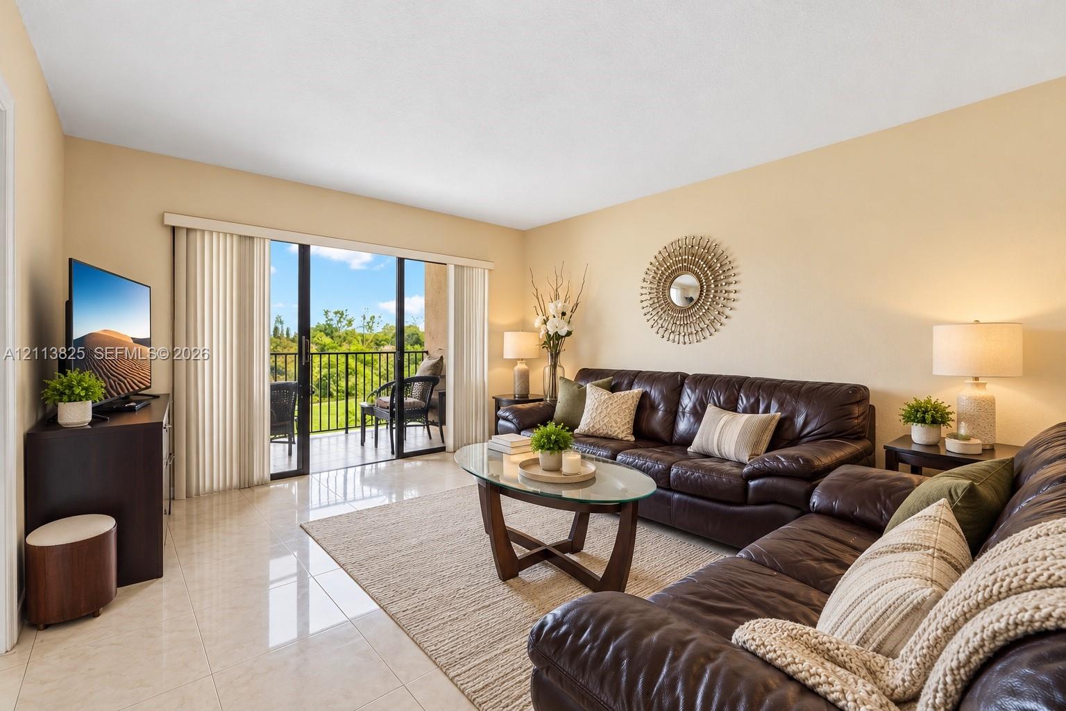 Living area featuring polished tile flooring and sliding glass doors with access to an exterior balcony