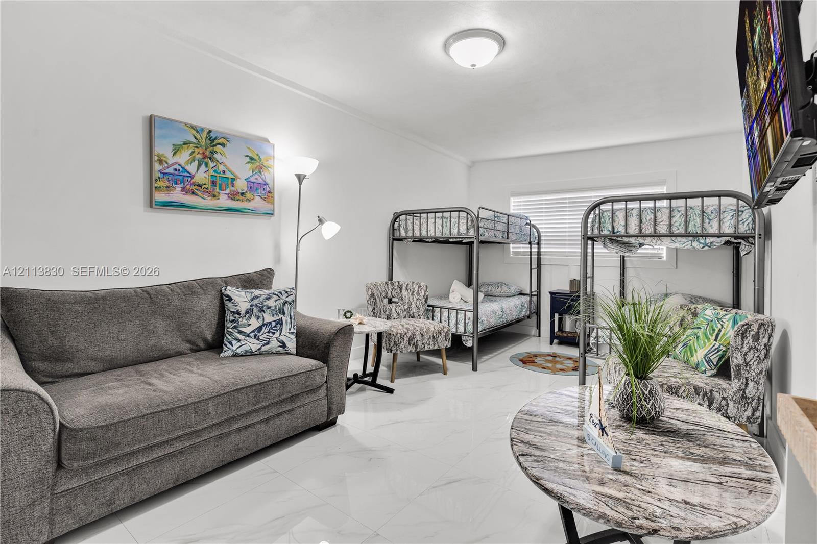 Large-format polished tile flooring, neutral wall tones, and recessed ceiling lighting with horizontal blinds