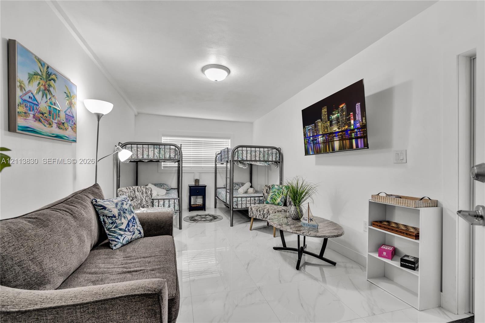Spacious room featuring polished stone-finish tile flooring, clean white walls, and a recessed ceiling light fixture