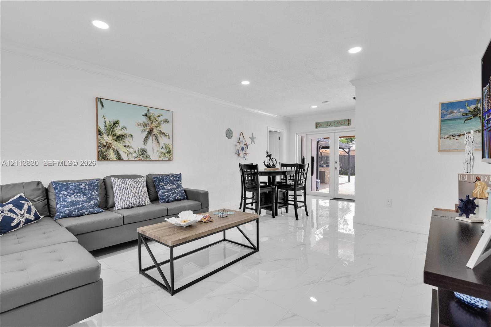 Large-format tile flooring, recessed ceiling lighting, and double glass doors