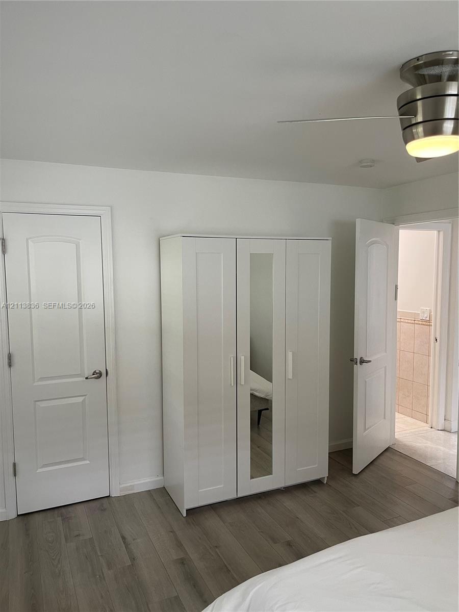 Wood-finish flooring, brushed nickel ceiling fan with integrated lighting, and solid core interior doors with brushed nickel hardware