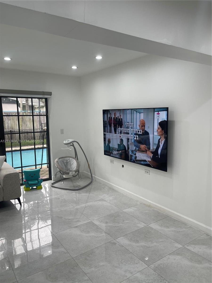Glossy tile flooring, recessed ceiling lighting, and a black-framed sliding glass door providing external exposure Glossy tile flooring, recessed ceiling lighting, and a black-framed sliding glass door providing external exposure