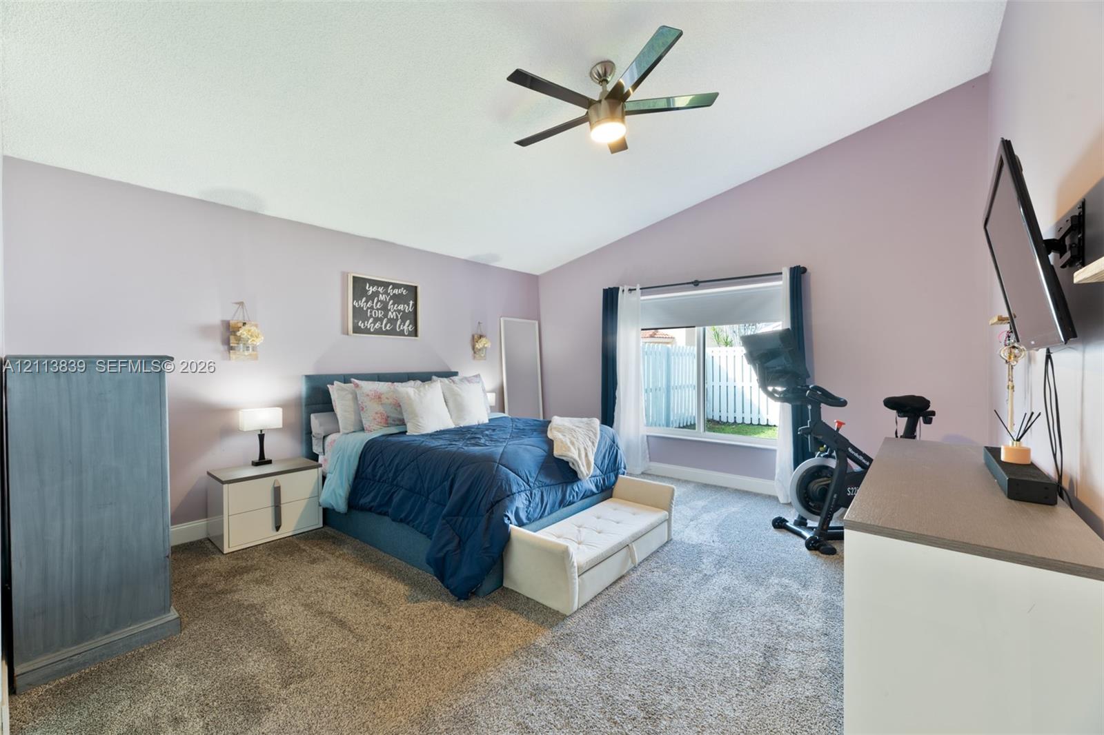 Vaulted ceiling with integrated multi-blade ceiling fan and wall-to-wall carpeting