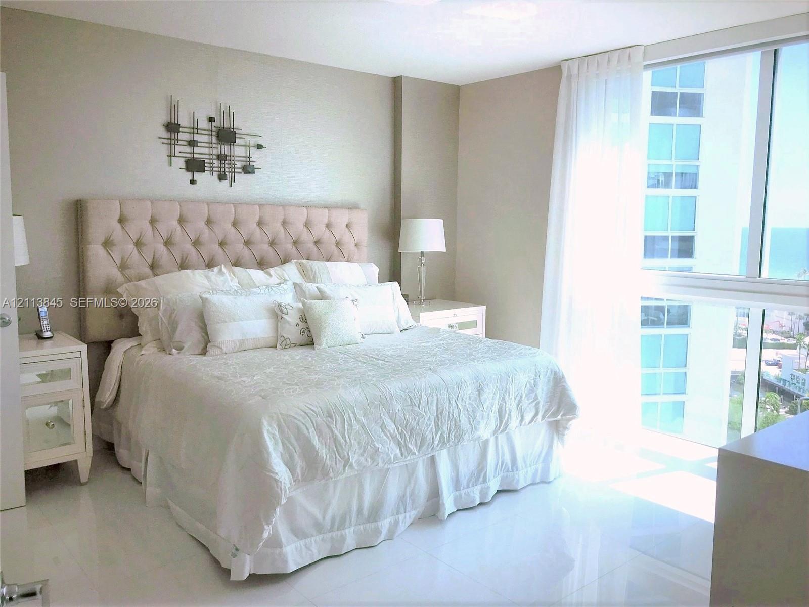 Floor-to-ceiling windows featuring exterior maritime scenery, paired with polished neutral-toned tile flooring Floor-to-ceiling windows featuring exterior maritime scenery, paired with polished neutral-toned tile flooring