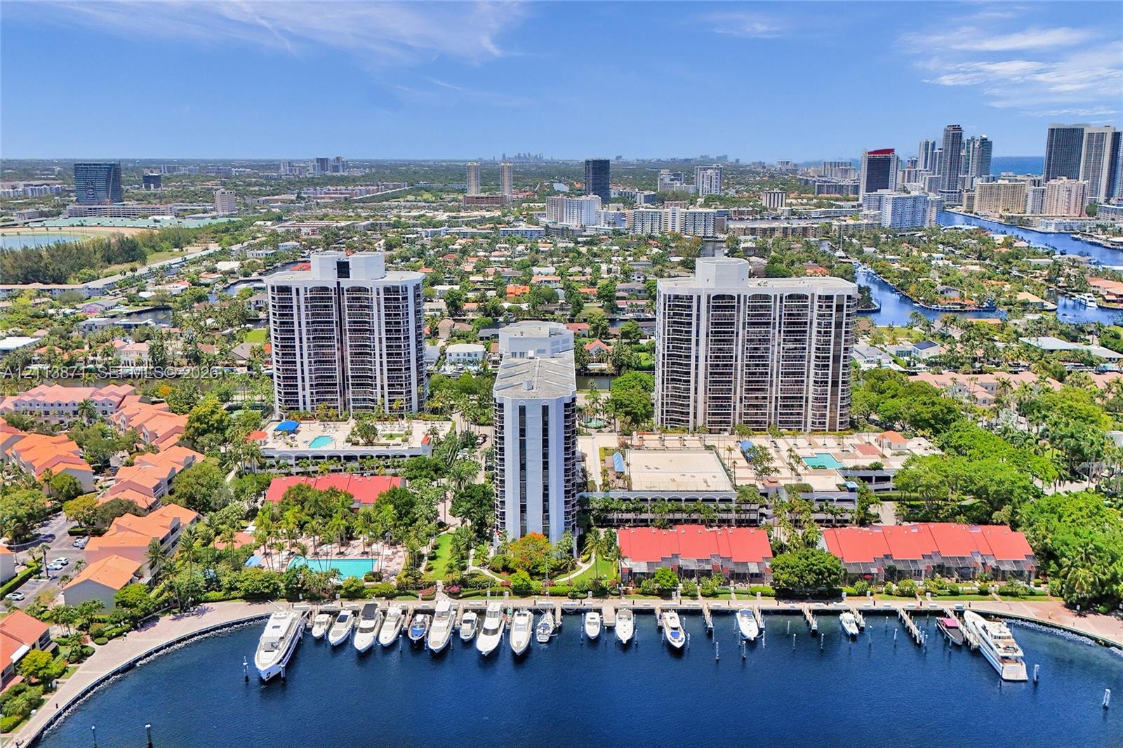 Aerial perspective of high-rise towers featuring deep-water boat slips, on-site swimming pools, and manicured tropical landscaping situated along a waterfront bulkhead Aerial perspective of high-rise towers featuring deep-water boat slips, on-site swimming pools, and manicured tropical landscaping situated along a waterfront bulkhead