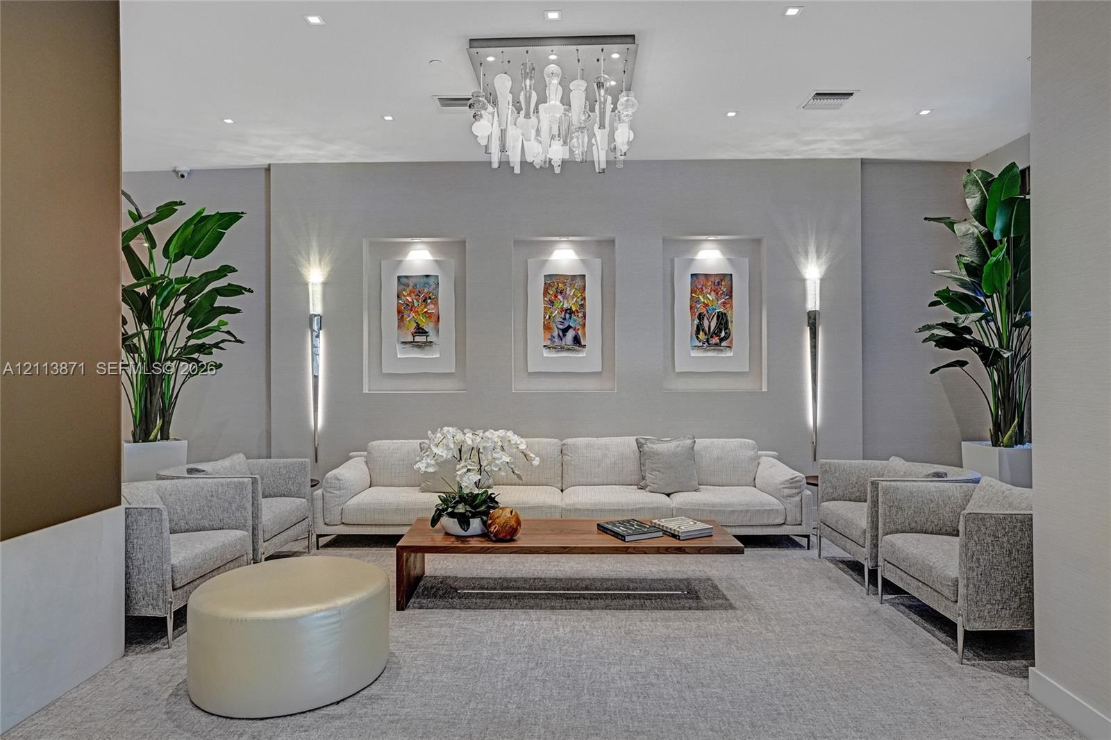 Artistic chandelier with hanging glass elements, recessed wall niches with integrated lighting, and dual wall-mounted light fixtures Artistic chandelier with hanging glass elements, recessed wall niches with integrated lighting, and dual wall-mounted light fixtures