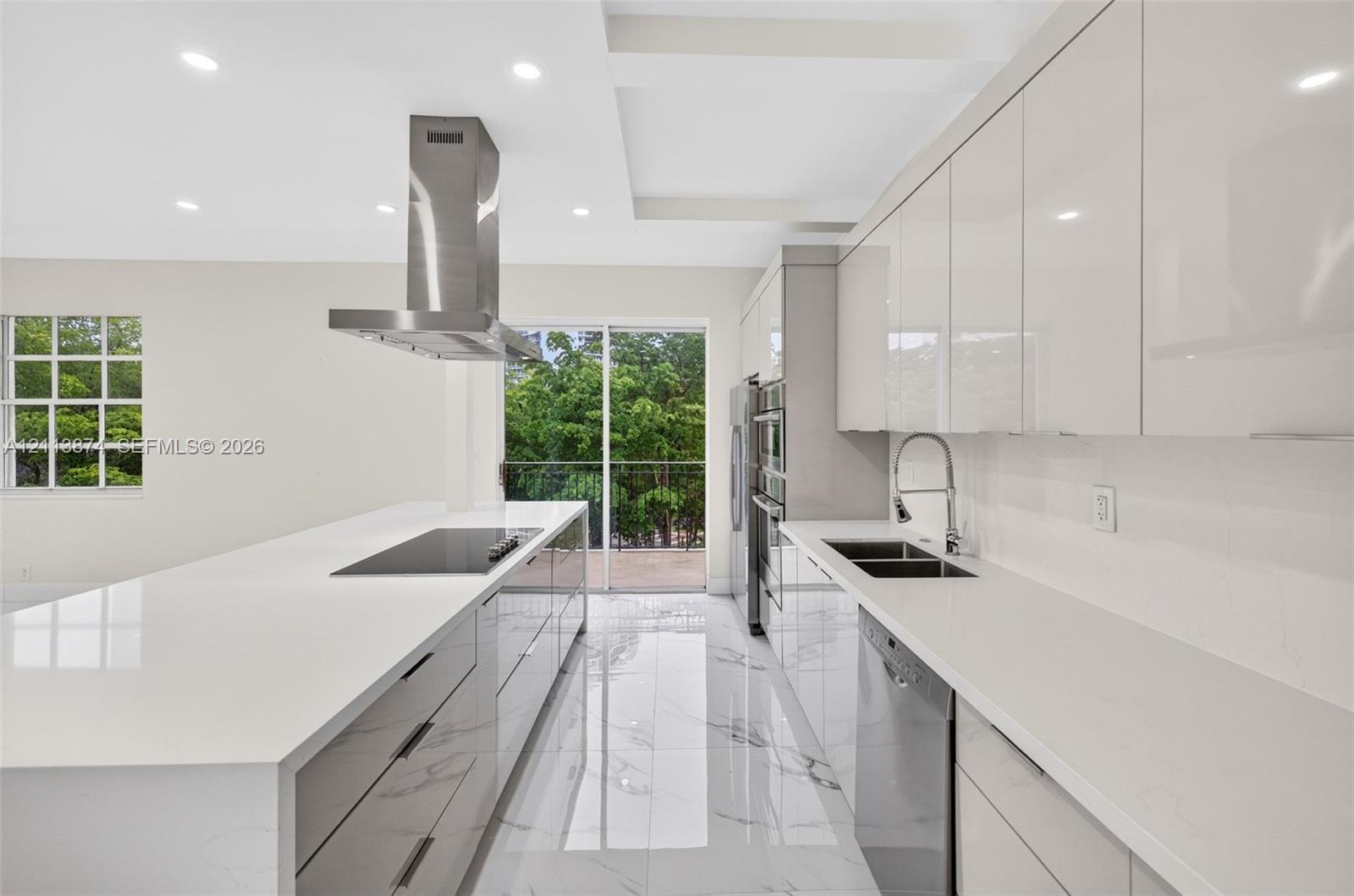 Kitchen featuring gloss-finish cabinetry, waterfall-edge quartz countertops, stainless steel appliances, stainless steel range hood, and porcelain tile flooring