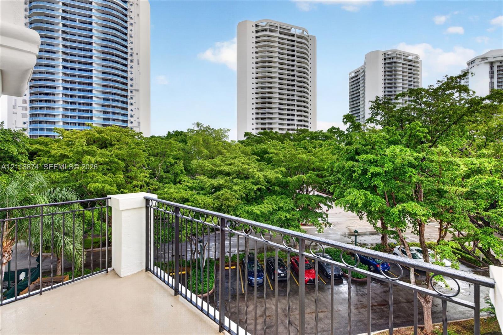 Covered terrace featuring decorative wrought iron railings and solid surface flooring