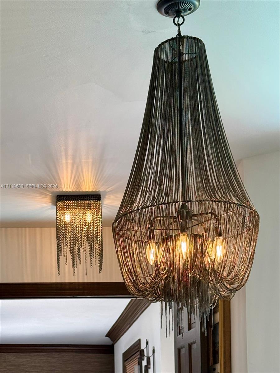 Tiered chandelier featuring draped metallic chain-link construction and a square flush-mount ceiling fixture with matching chain detailing and exposed bulbs