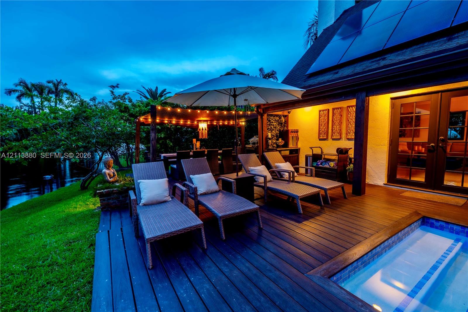 Wood-finish deck featuring an integrated pool, covered pergola structure, and glass-paned double doors