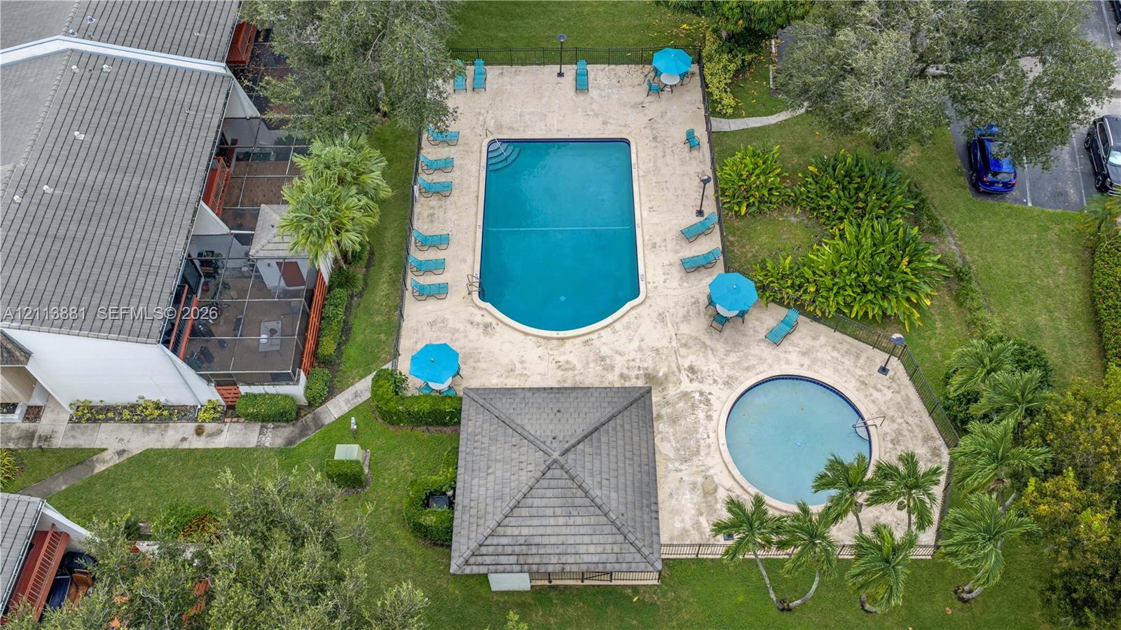 Outdoor recreation area featuring a swimming pool, circular wading pool, stone-finish deck, and covered pavilion