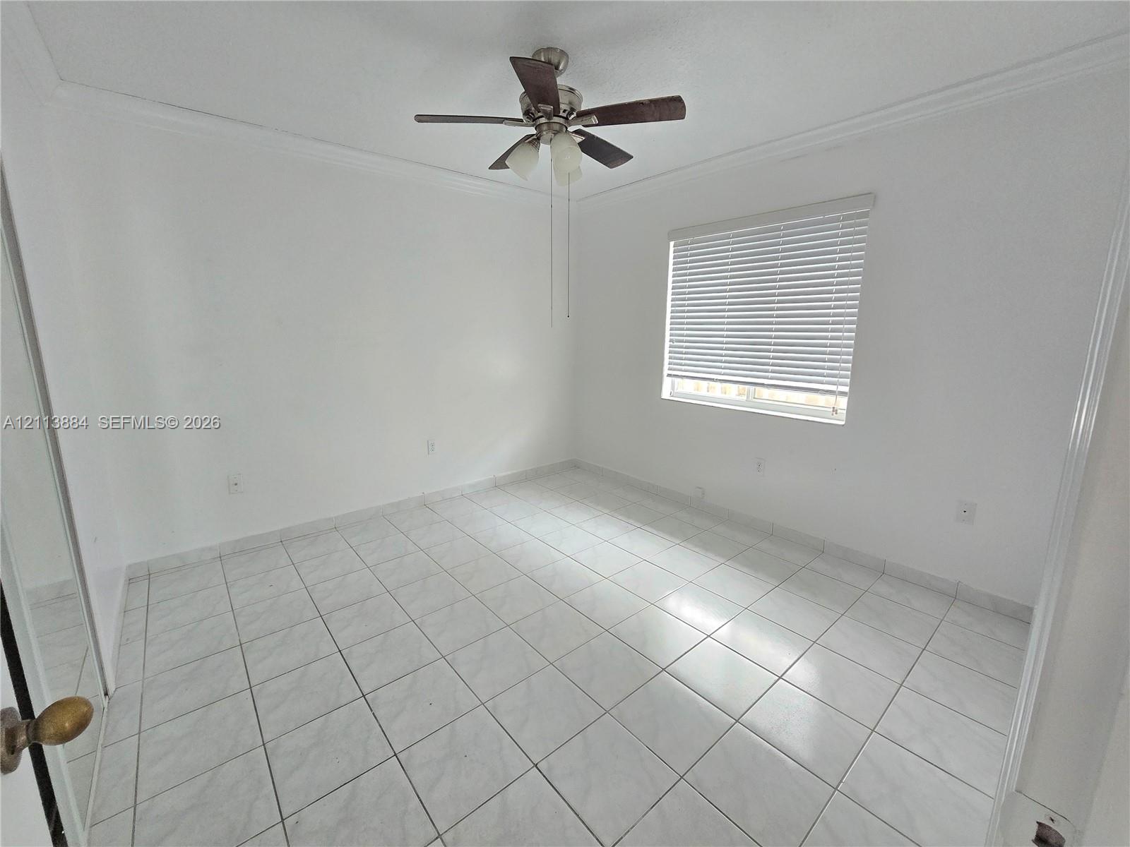 Neutral-toned tile flooring, ceiling fan with integrated lighting, and horizontal window blinds