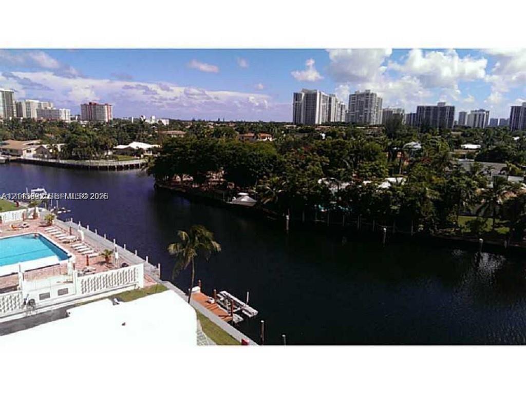 Waterfront exterior featuring a swimming pool, paved pool deck, and private boat dock Waterfront exterior featuring a swimming pool, paved pool deck, and private boat dock