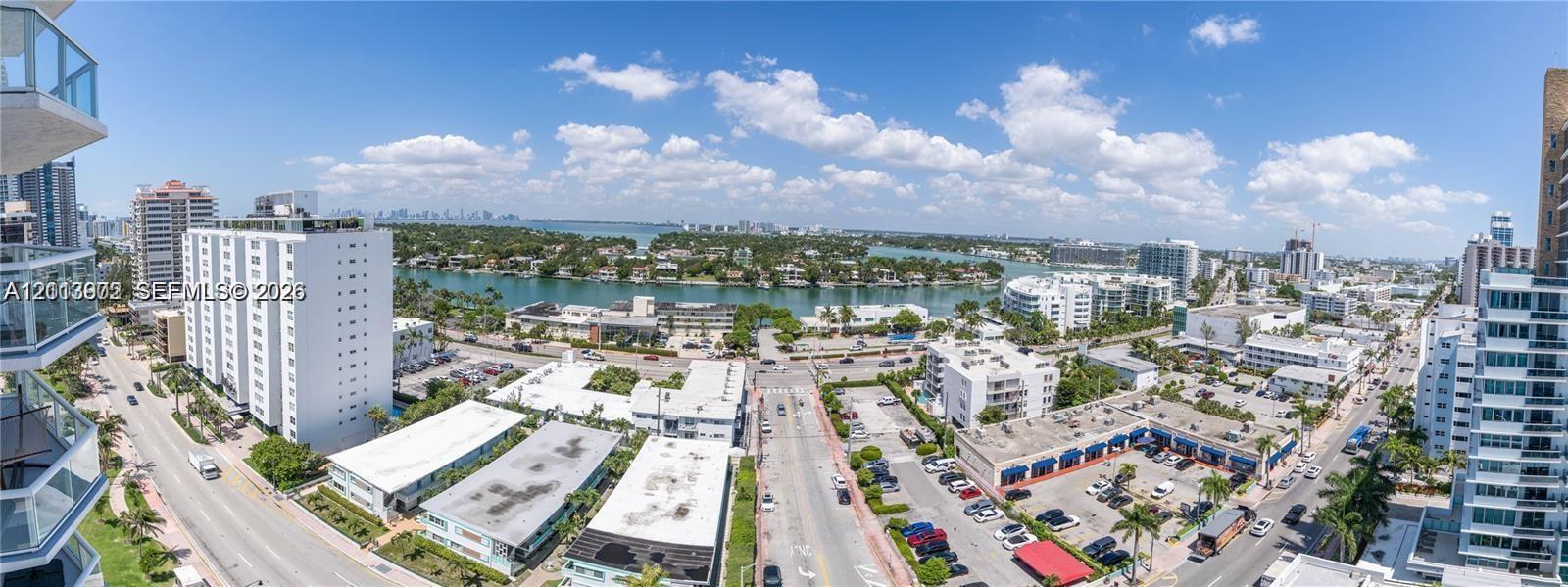 High-rise exterior with glass balcony railings, panoramic urban surroundings, and direct exposure to coastal waterways