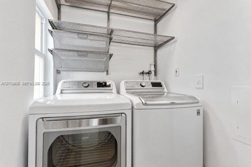 Laundry area featuring wall-mounted wire shelving, two pull-out metal storage baskets, and high-capacity laundry appliances