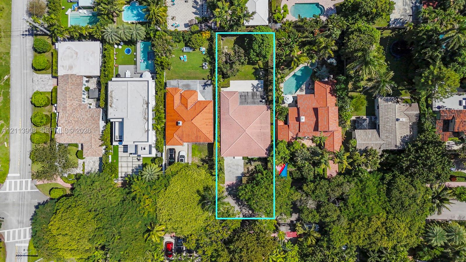 Aerial perspective featuring a lot with mature landscaping, an expansive rear lawn, and a multi-pitched roofline