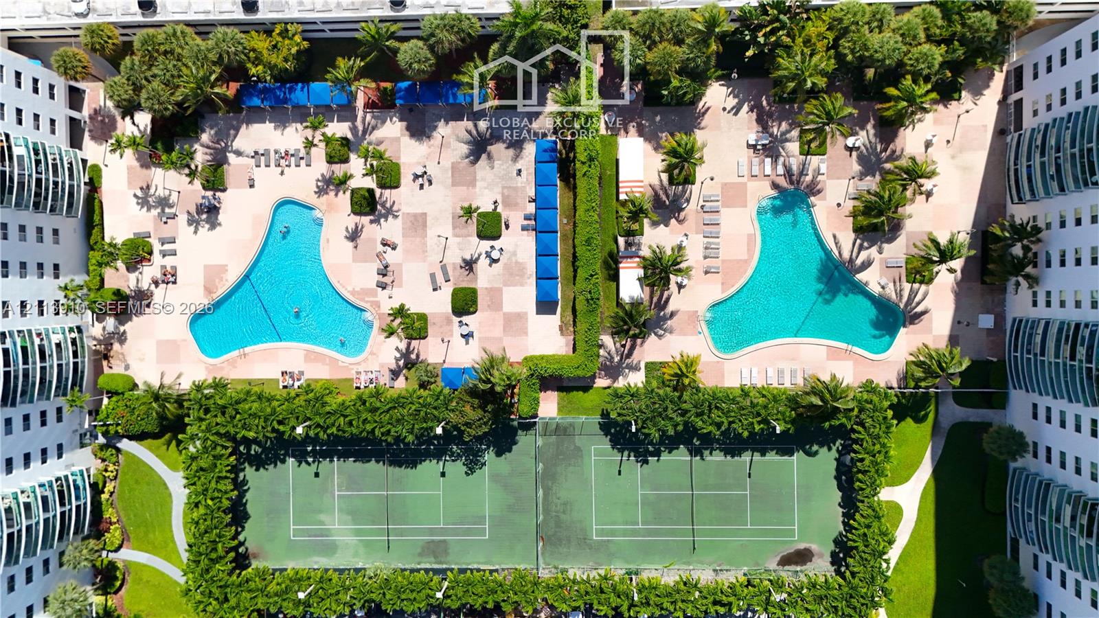 Recreational area featuring two outdoor swimming pools, two hard-court tennis courts, paved decking, and mature landscaping Recreational area featuring two outdoor swimming pools, two hard-court tennis courts, paved decking, and mature landscaping