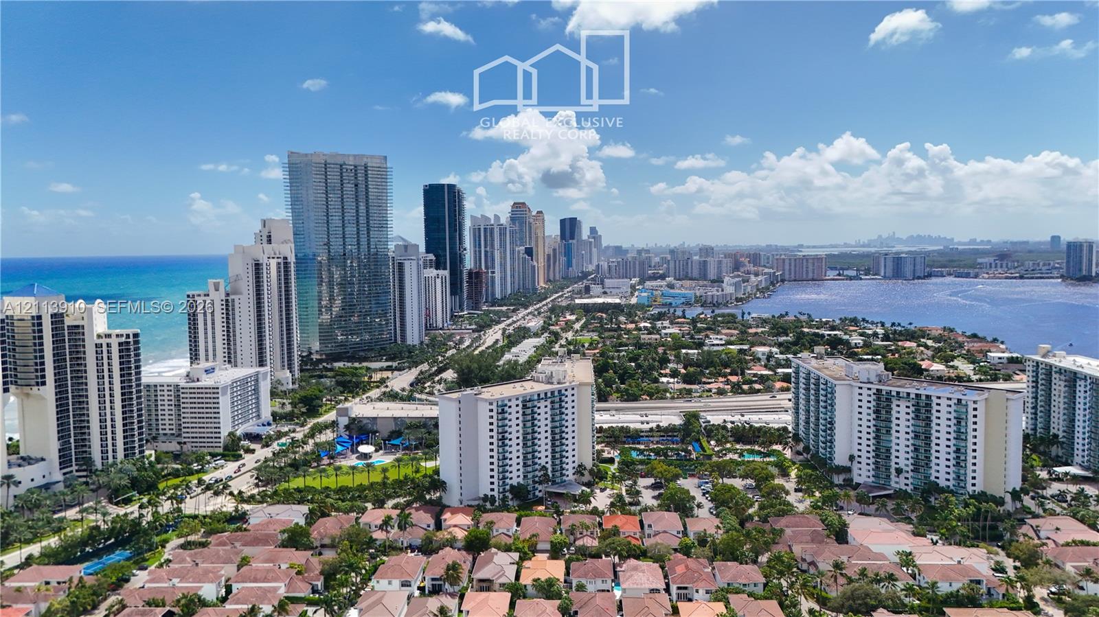 Aerial perspective of a coastal urban landscape featuring ocean and bay shorelines, high-rise buildings, and dense residential development Aerial perspective of a coastal urban landscape featuring ocean and bay shorelines, high-rise buildings, and dense residential development