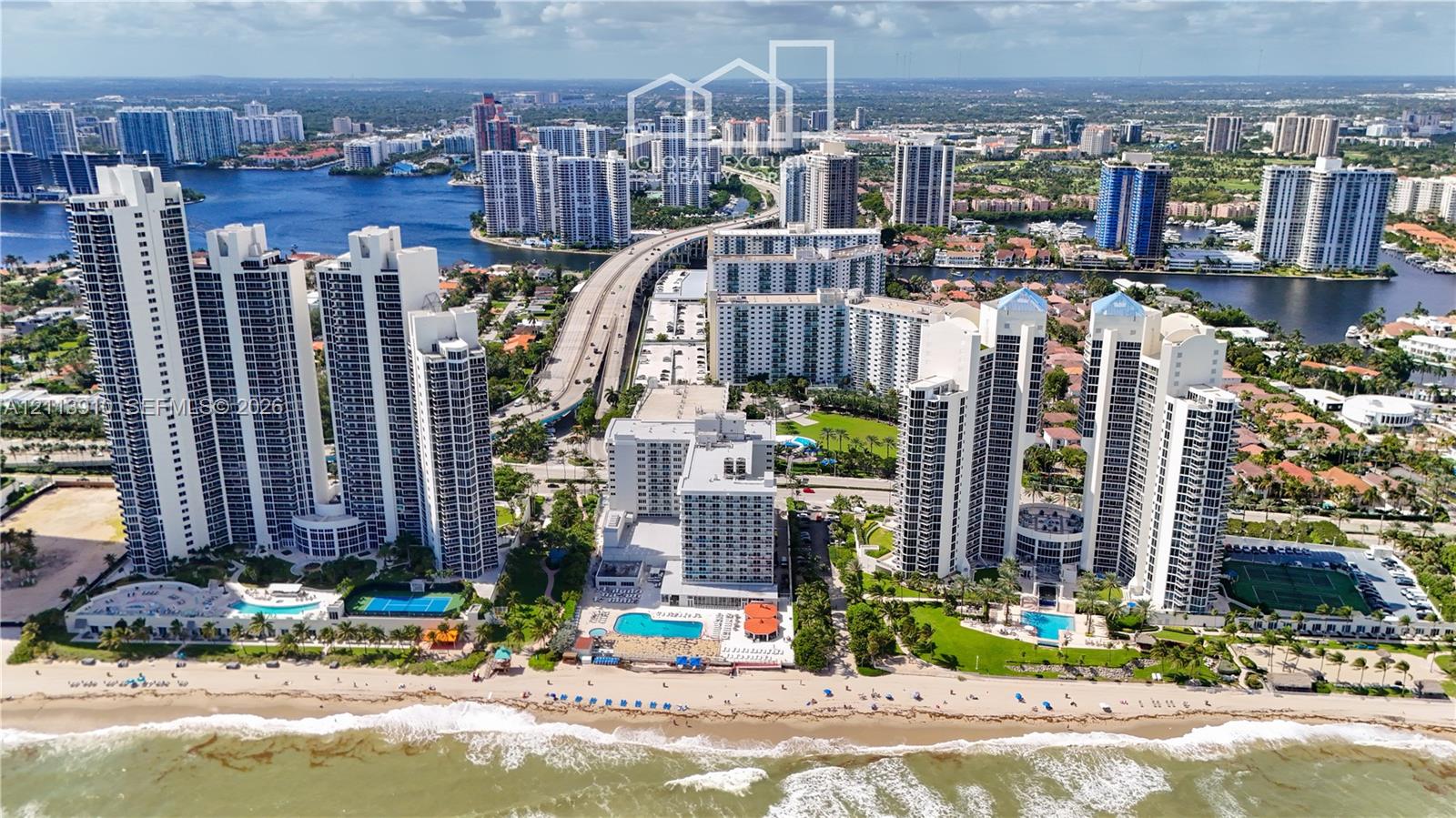 Aerial perspective of waterfront high-rise residential towers featuring direct beach access, outdoor swimming pools, and tennis courts Aerial perspective of waterfront high-rise residential towers featuring direct beach access, outdoor swimming pools, and tennis courts