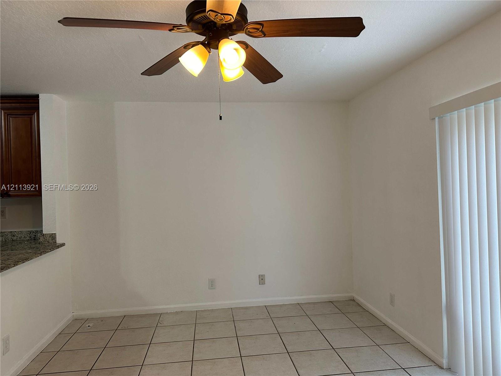 Tile flooring, ceiling fan with integrated light fixture, and vertical window blinds