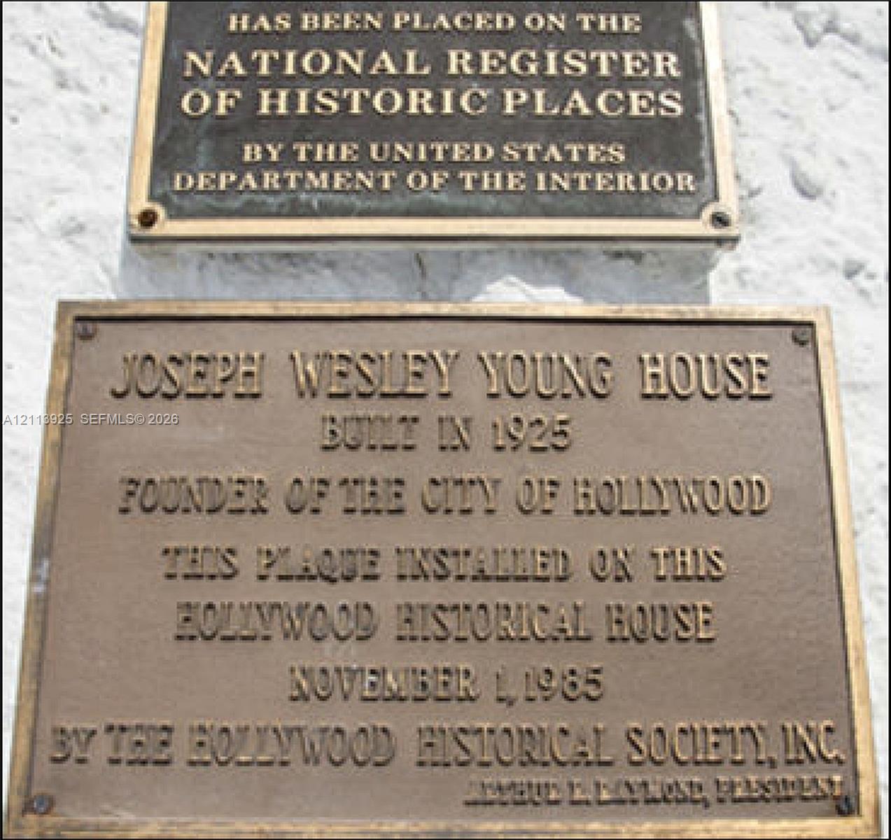 Bronze historical plaques recognizing the property as a site on the National Register of Historic Places and a documented historical residence built in 1925