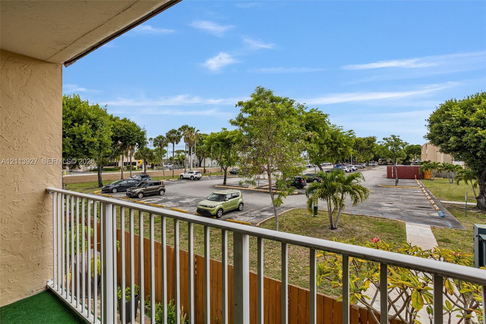 Outdoor balcony featuring a vertical metal railing and wood-finish privacy screening