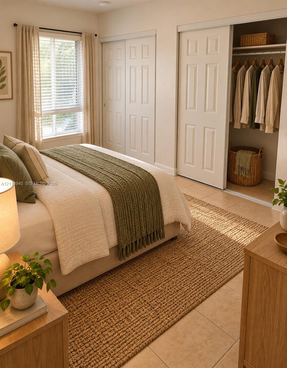 Tile flooring, sliding closet doors, and large windows with horizontal blinds