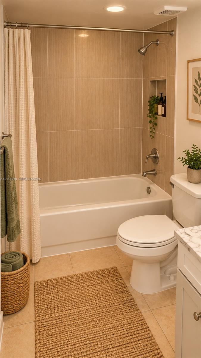 Bathroom featuring a tub-shower combination with vertical tile surround, integrated wall niche, and polished metal fixtures, complemented by a white vanity with a stone-finish countertop