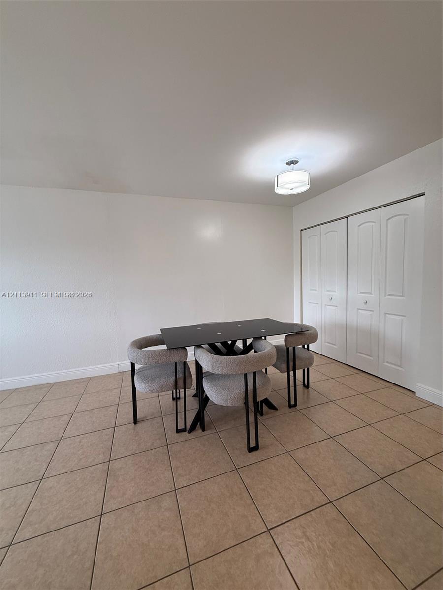 Ceramic tile flooring, double-panel closet doors, and drum-style ceiling light fixture