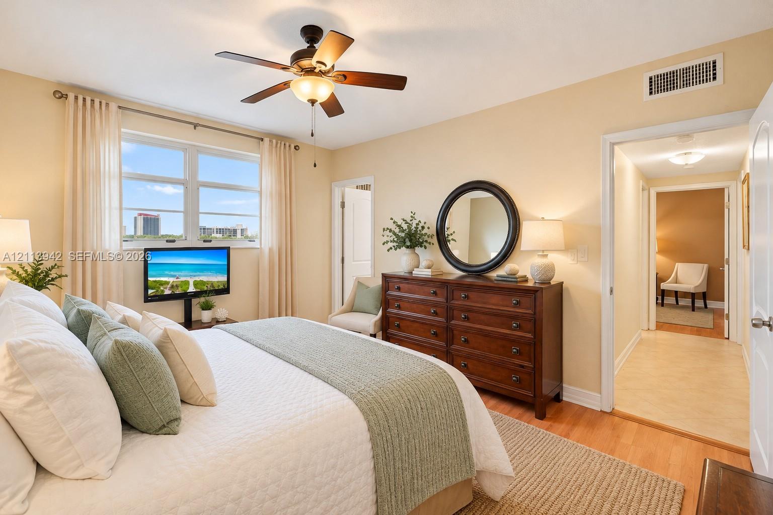 Bedroom featuring wood-finish flooring, a ceiling fan with integrated lighting, and dual-pane windows