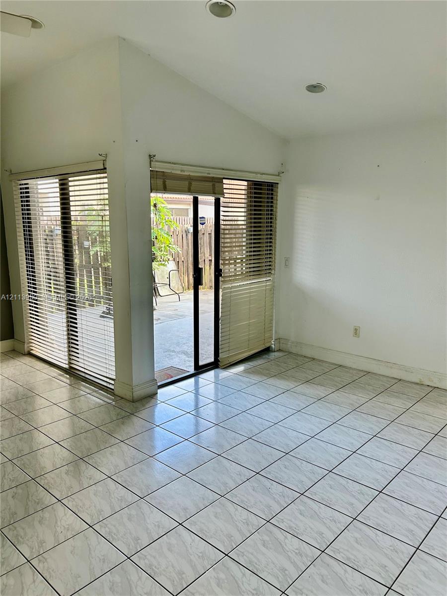 Ceramic tile flooring, vaulted ceiling with recessed lighting, and corner sliding glass doors Ceramic tile flooring, vaulted ceiling with recessed lighting, and corner sliding glass doors