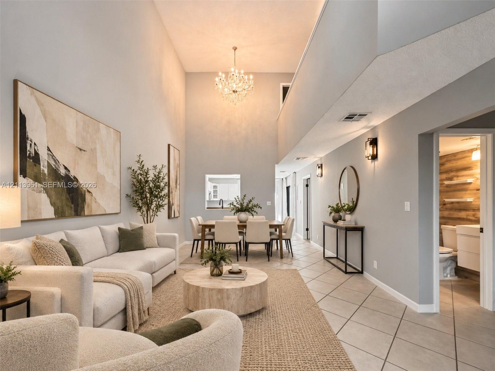 Two-story vaulted ceilings featuring a crystal chandelier and tile flooring Two-story vaulted ceilings featuring a crystal chandelier and tile flooring