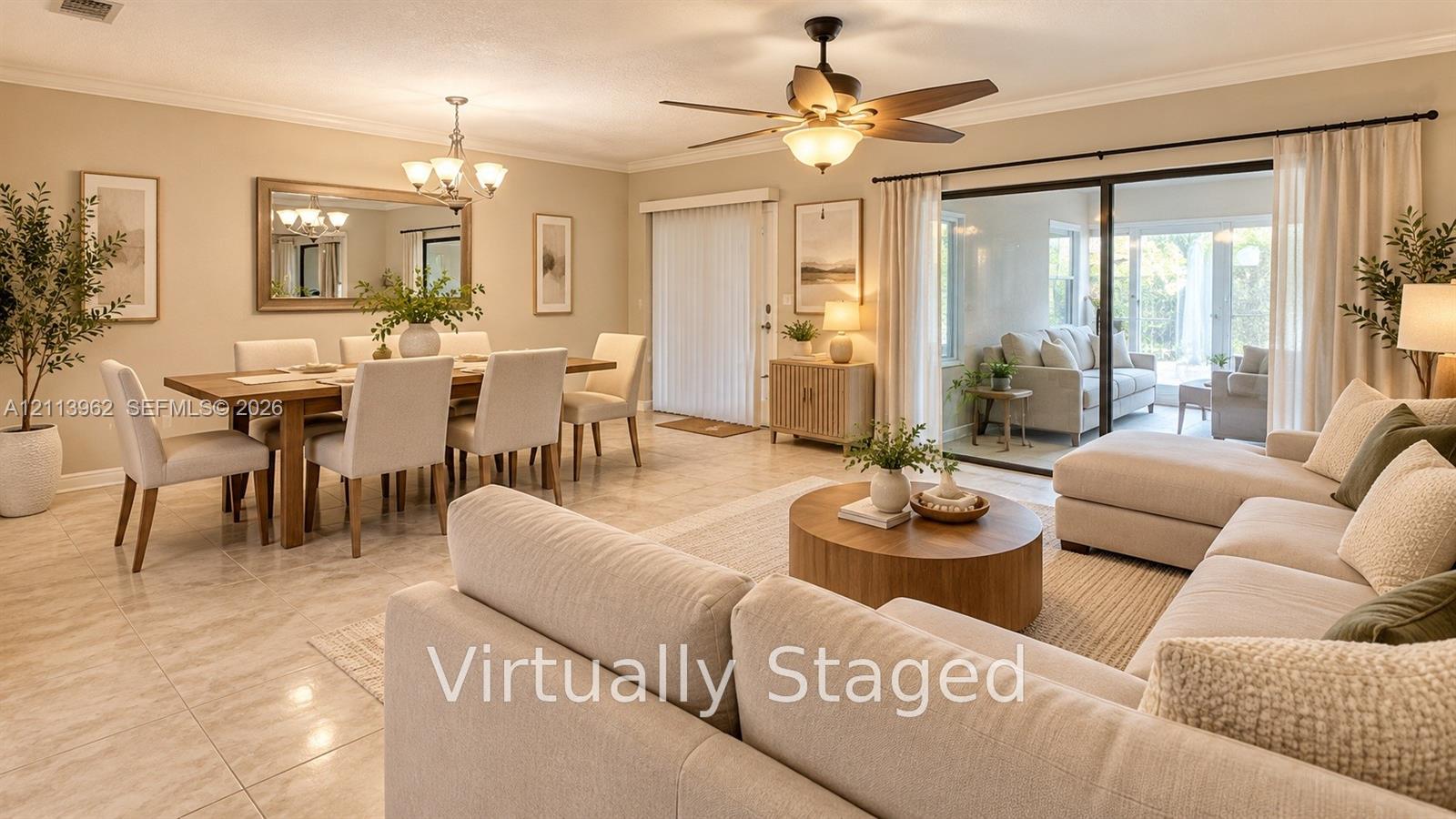 Open-concept interior featuring large-format tile flooring, a multi-blade ceiling fan with integrated lighting, crown molding, and sliding glass doors Open-concept interior featuring large-format tile flooring, a multi-blade ceiling fan with integrated lighting, crown molding, and sliding glass doors