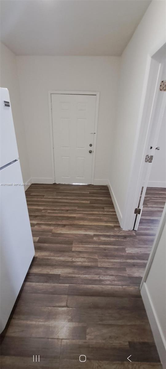 Wood-finish flooring, white panel door, and white refrigerator Wood-finish flooring, white panel door, and white refrigerator