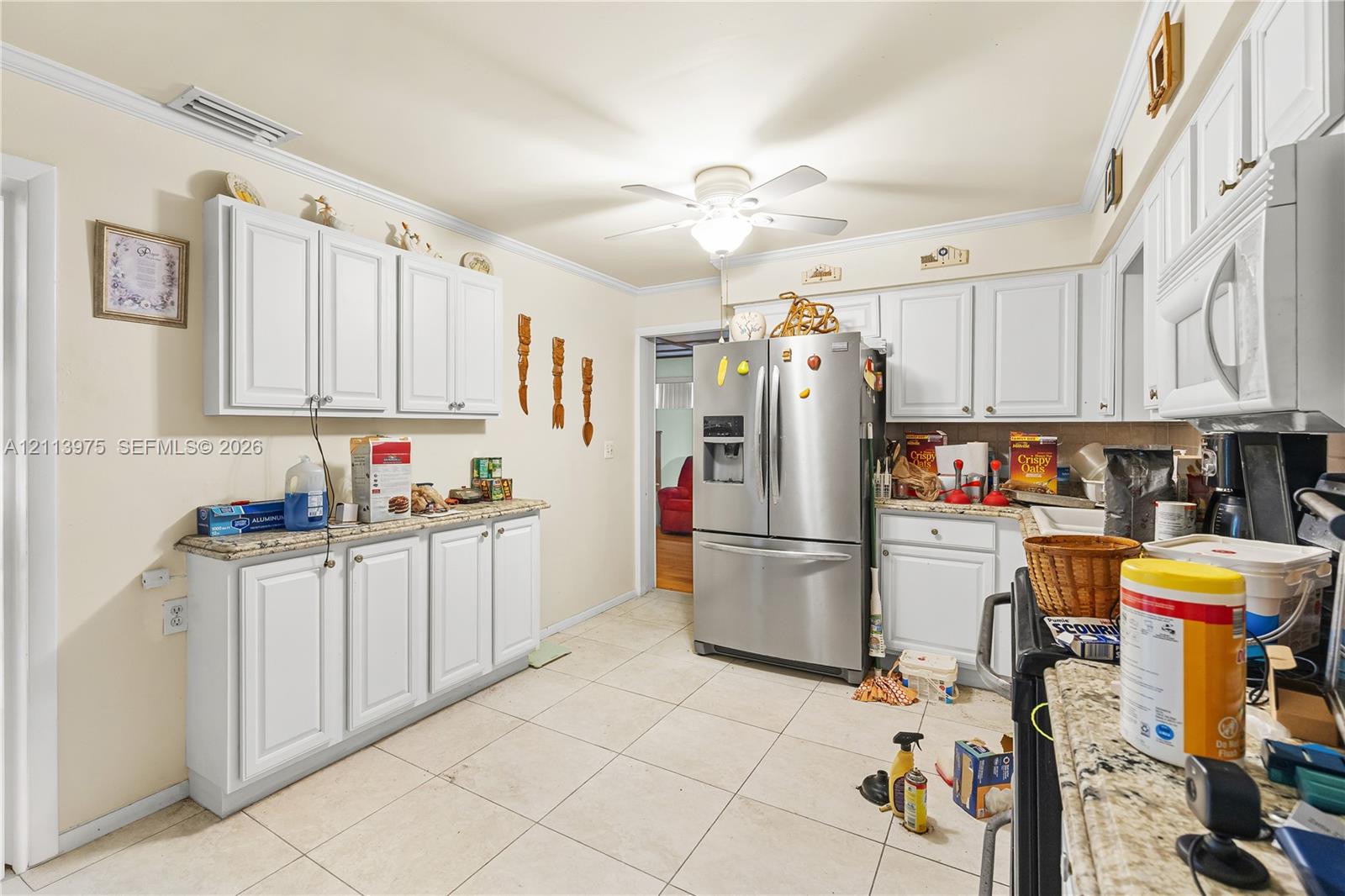 Kitchen featuring white cabinetry, stone-finish countertops, tile flooring, stainless steel French door refrigerator, and built-in microwave