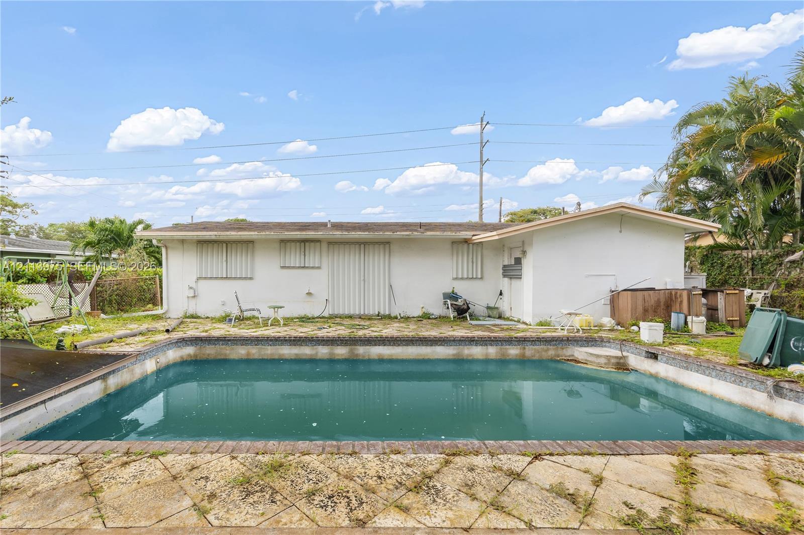 In-ground swimming pool with a stone paver patio