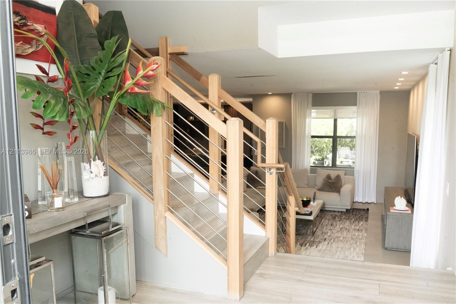 Staircase featuring light wood framing and horizontal steel tension cables, complemented by light wood-finish flooring and recessed ceiling lighting Staircase featuring light wood framing and horizontal steel tension cables, complemented by light wood-finish flooring and recessed ceiling lighting