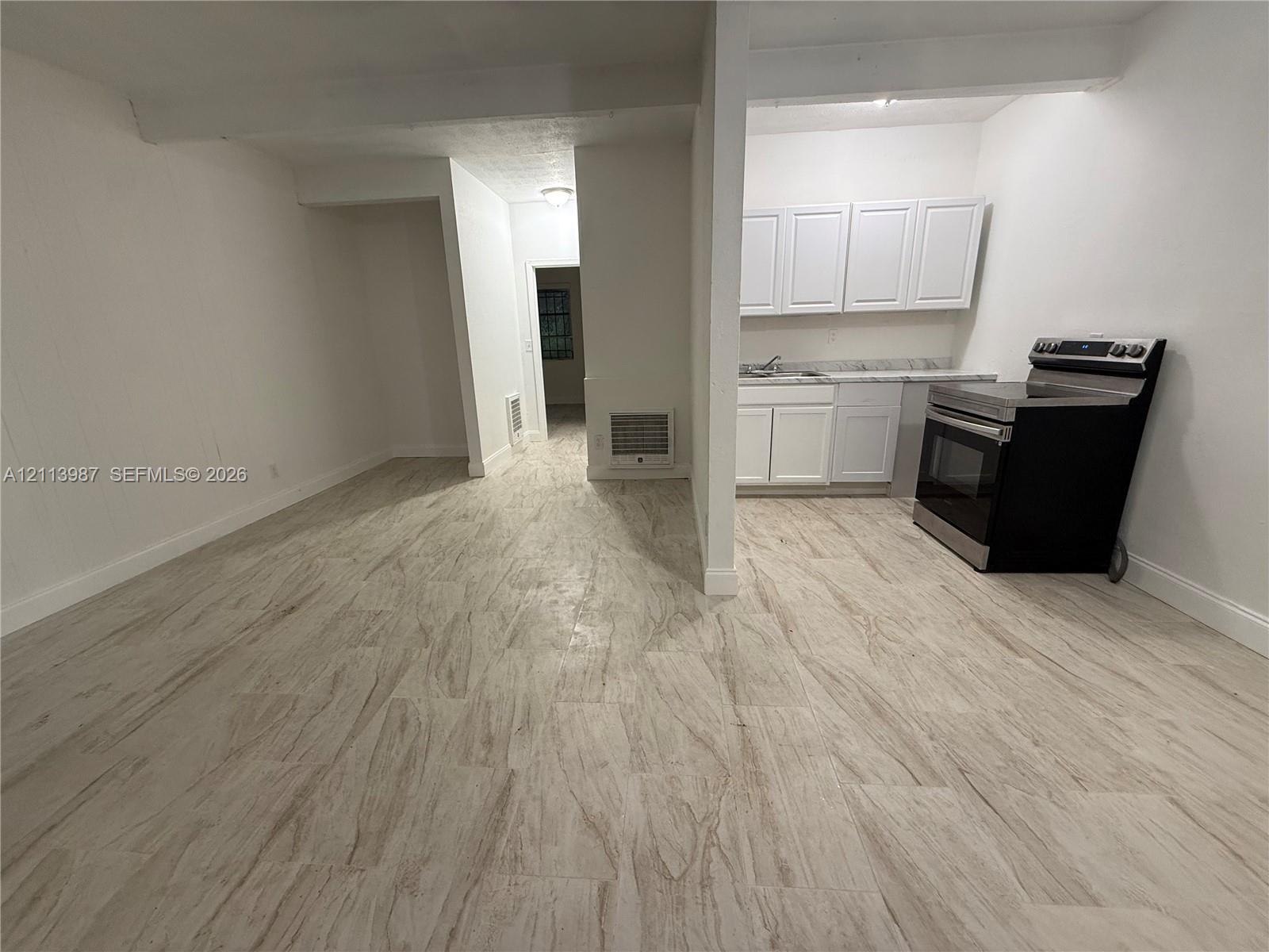 Wood-finish flooring throughout, white cabinetry with stone-finish countertops, and stainless steel range Wood-finish flooring throughout, white cabinetry with stone-finish countertops, and stainless steel range