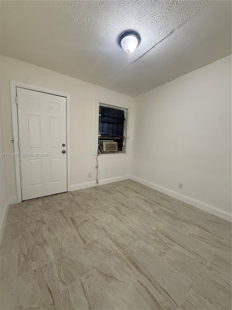 Neutral-toned tile flooring, solid-core interior door, and flush-mount ceiling light fixture