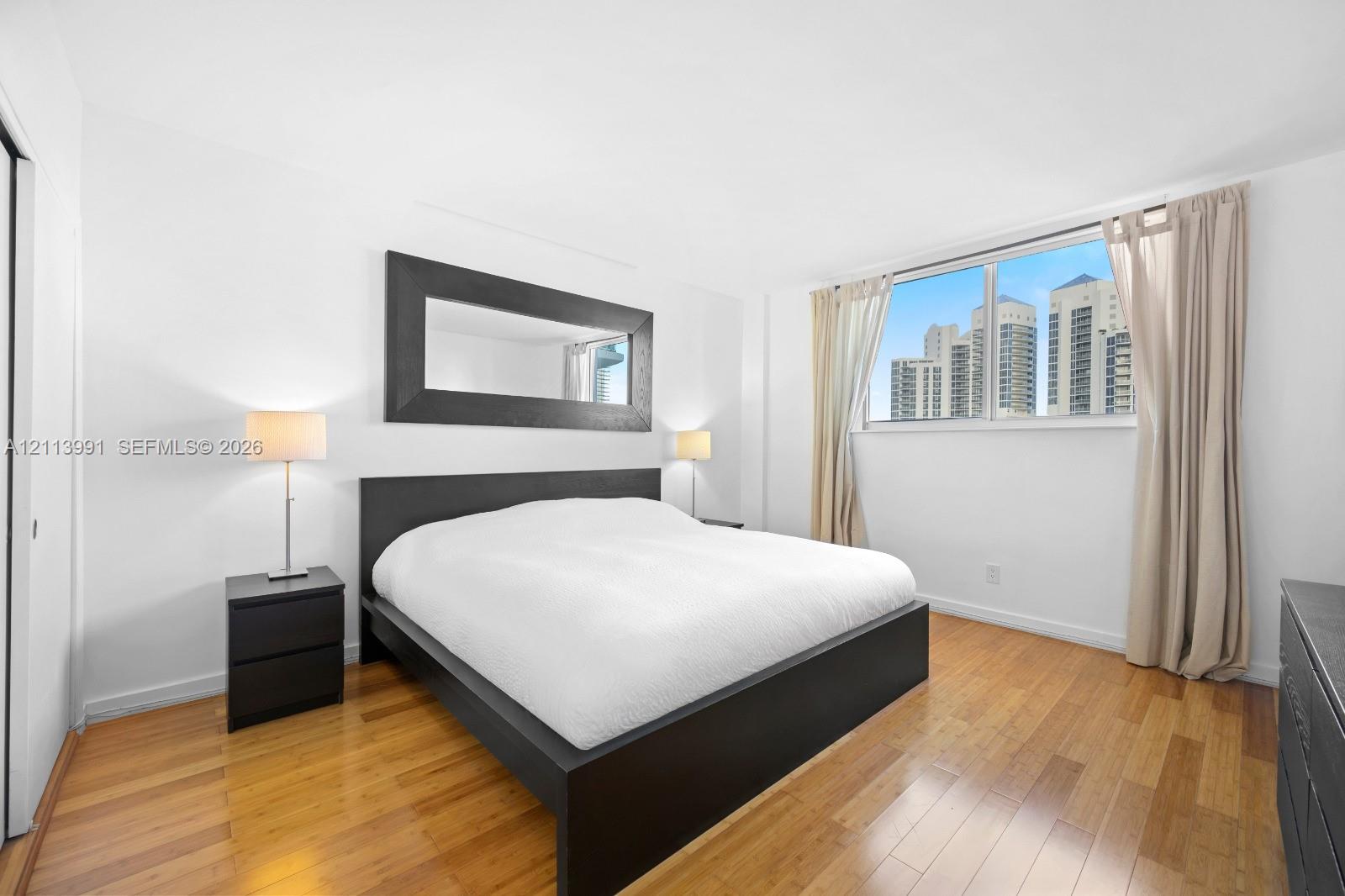 Wood-finish flooring, expansive window, and wall-mounted mirror