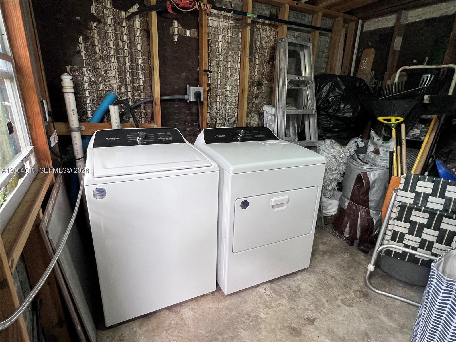 Top-loading washing machine and matching dryer pair situated on a concrete floor