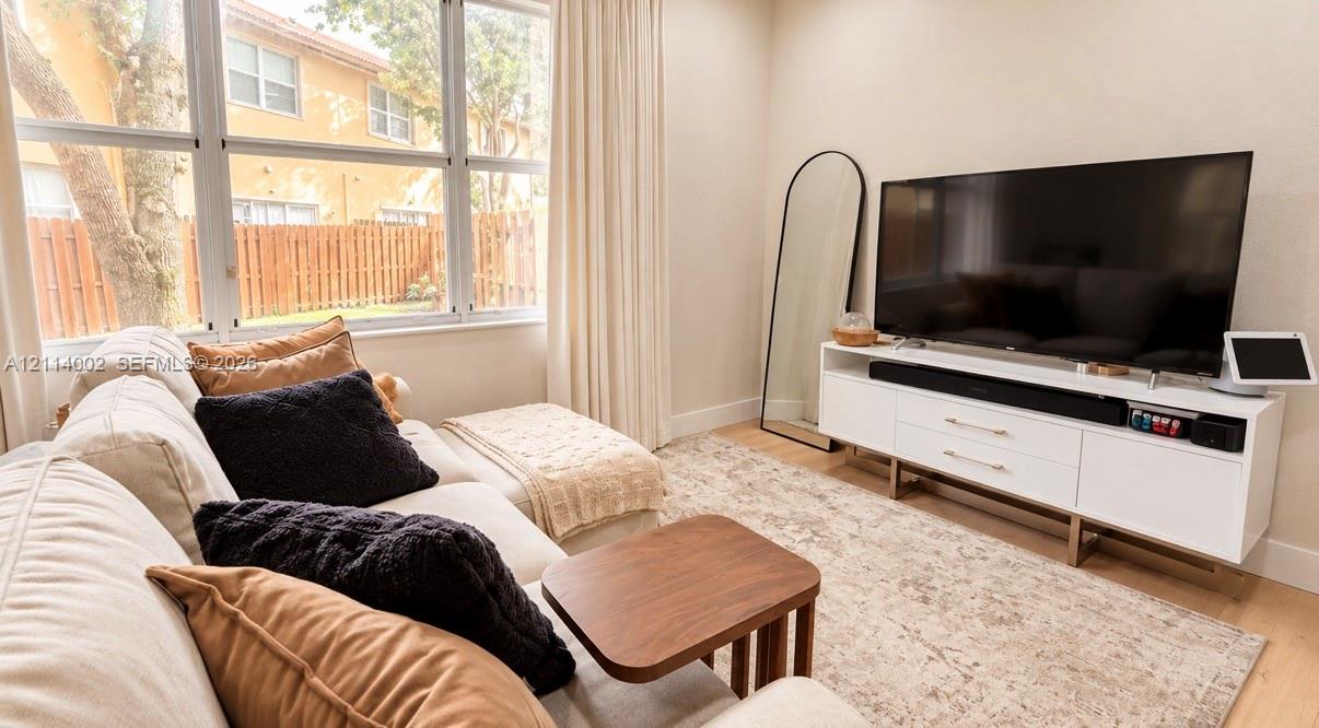 Large multi-pane windows with light-filtering curtains and wood-finish flooring