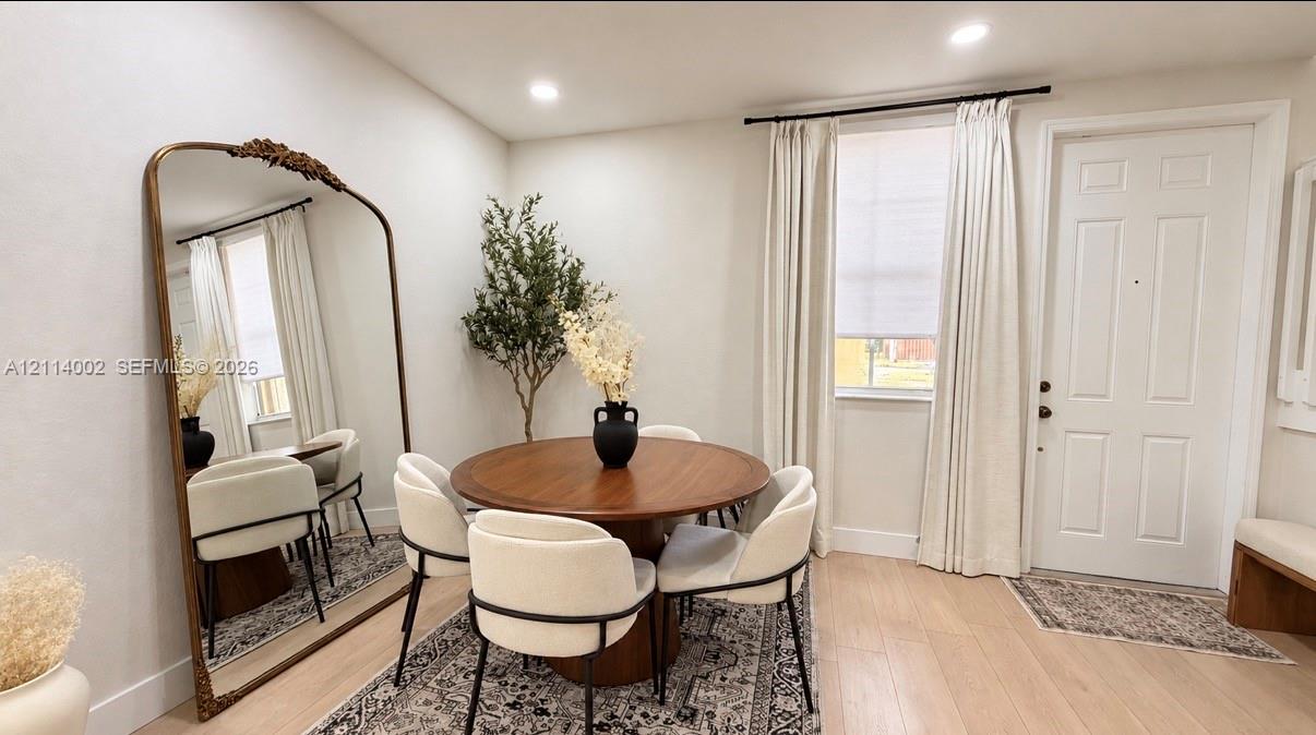 Neutral interior space featuring wood-finish flooring, recessed lighting, and a multi-panel exterior entry door